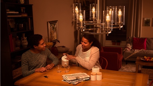 Une femme visse une ampoule à la maison