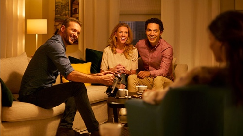 People enjoying the warm glow of a dimmed light bulb in a living room