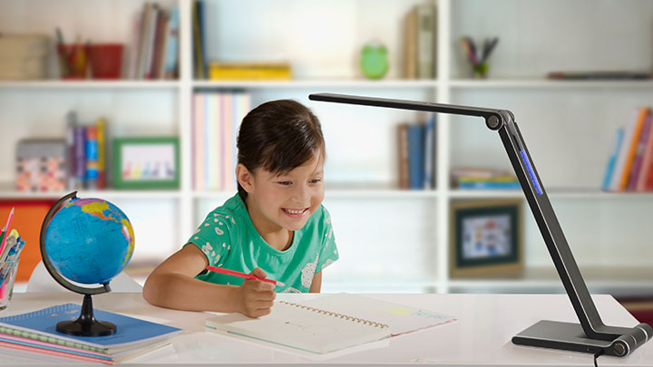 Girl doing homework under a Philips LED desk lighting