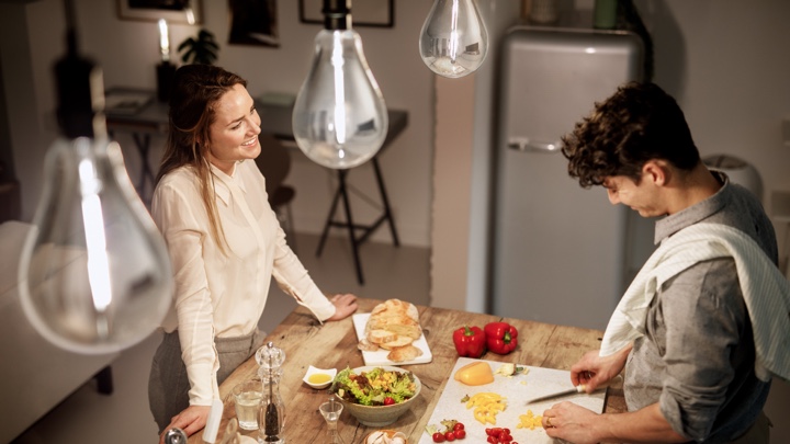 Vue d'en haut d'un homme et d'une femme qui préparent un souper dans une cuisine bien éclairée