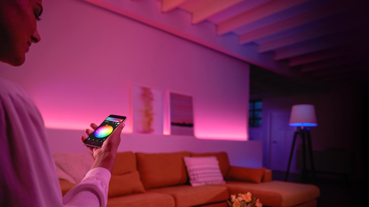 Person controlling colored lights in the living room