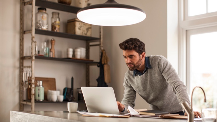 un homme travaillant de la maison sous un luminaire intelligent